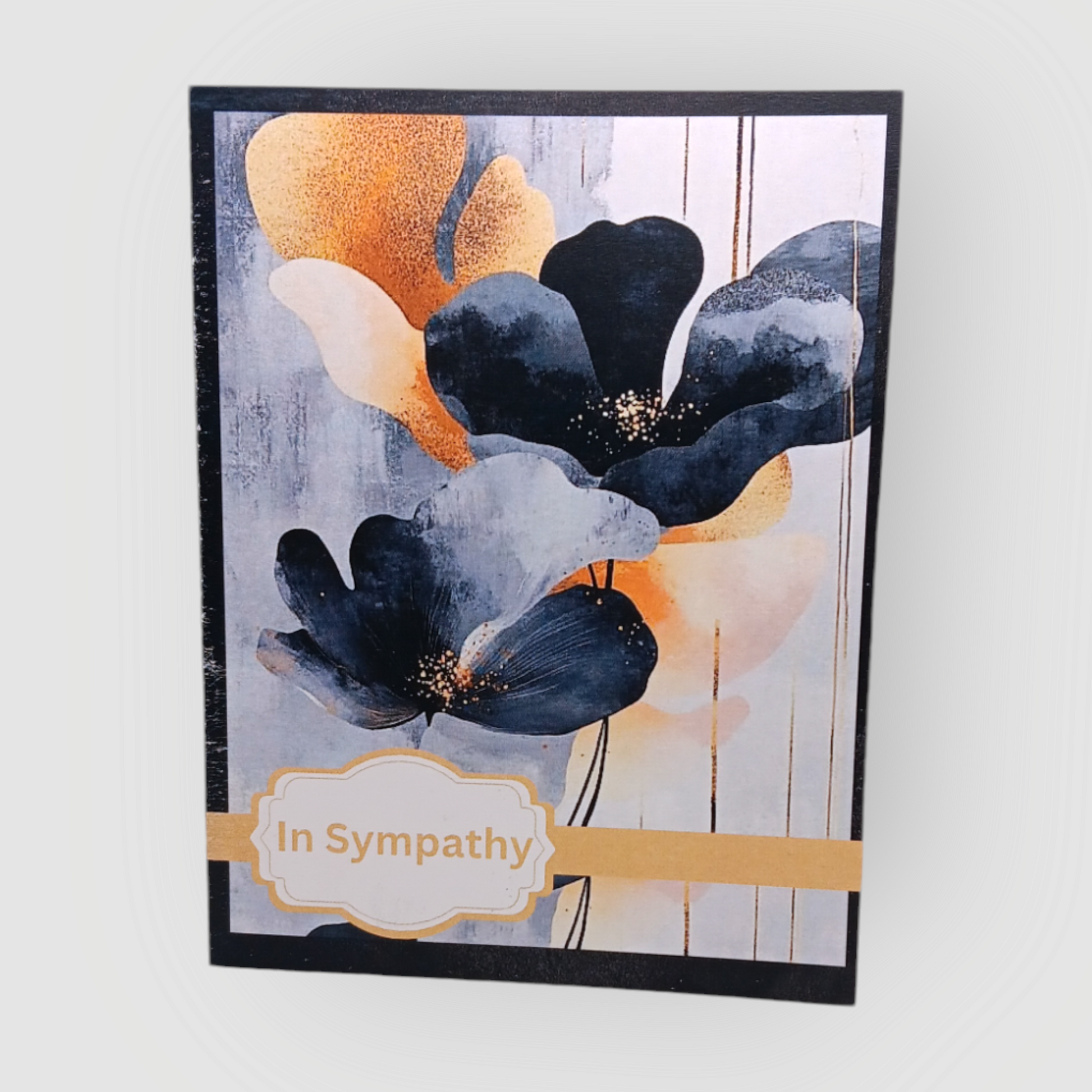 Sympathy note card with deep blue and gold flowers, labeled “In Sympathy” in a gold-accented frame.
Image Description: A sympathy card with anemone-like flowers in shades of blue-black, gold, and cream. The cover reads “In Sympathy,” with a blank inside for a personal message.