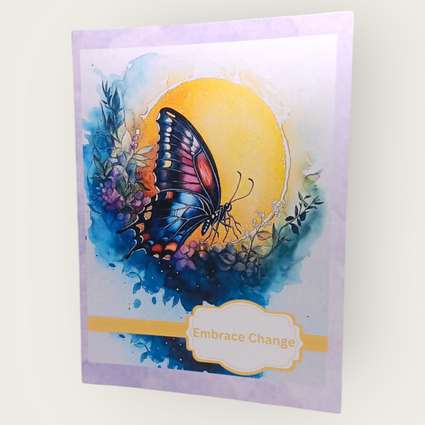 Note card with a butterfly in profile flying across a sun, with the message “Embrace Change” on the cover.
Image Description: A note card showing a butterfly in profile against a soft sun with the words “Embrace Change.” The inside is blank